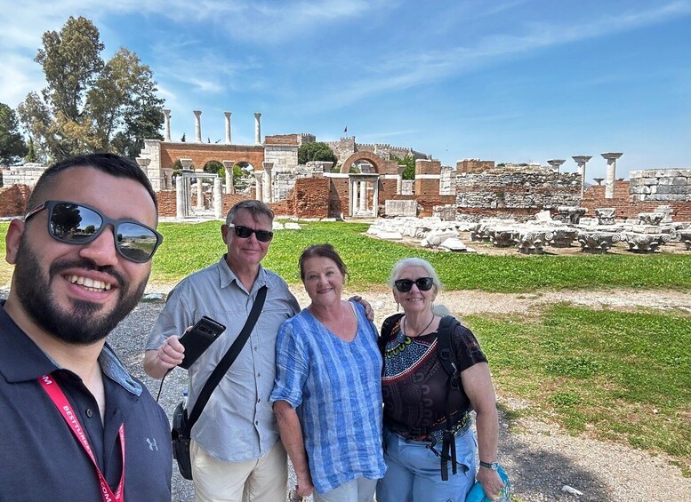 A group of people standing in front of ancient ruins with columns and arches. 2