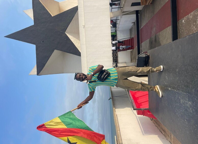 A person holding a flag with a star and stripes, standing in front of a large star and a red and white striped wall. 3