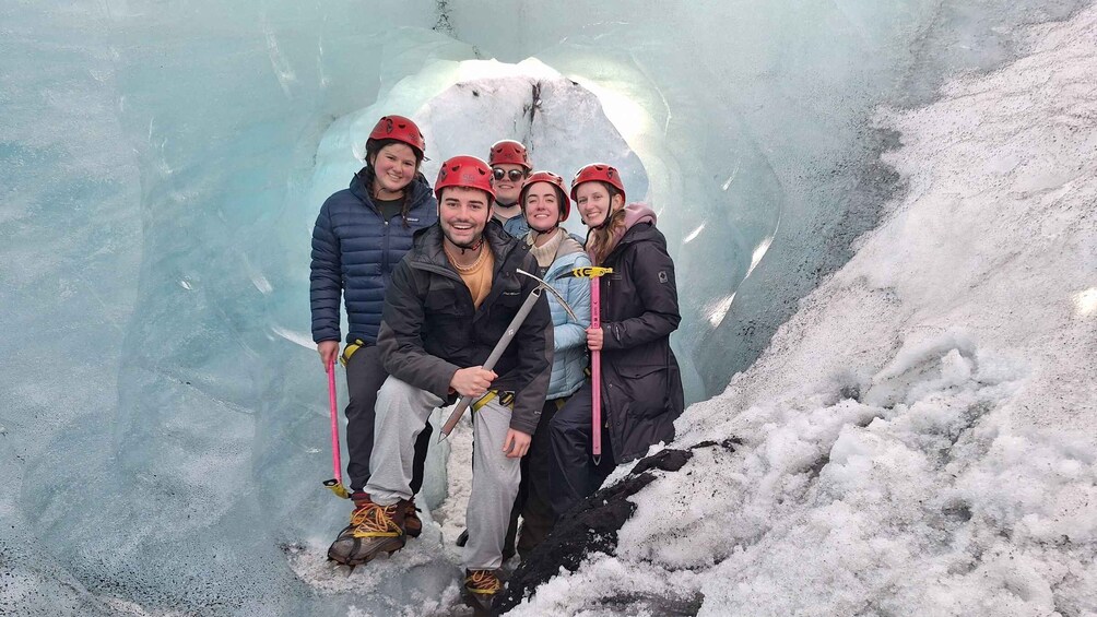 A group of people in a glacier cave with ice tools. 5