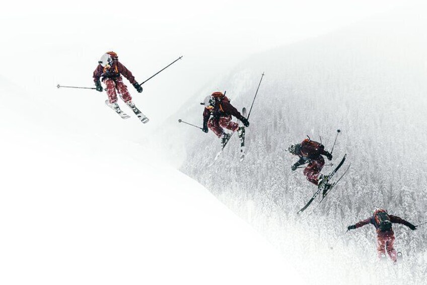 Four skiers descending a snowy slope. 4