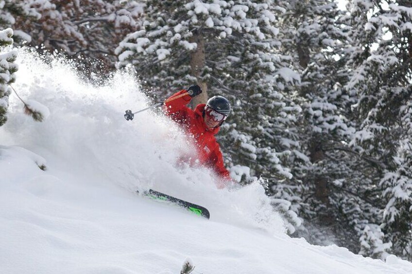 A skier in a red outfit performing a turn on a snowy slope. 2