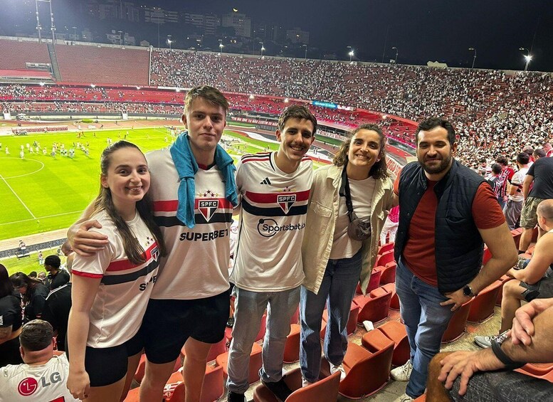 A group of people in a stadium with a soccer field. 5