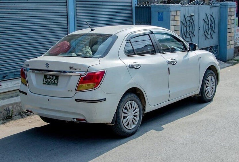 Une berline Suzuki blanche est garée dans la rue. 3