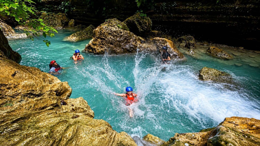 People kayaking in a rocky river surrounded by cliffs. 5