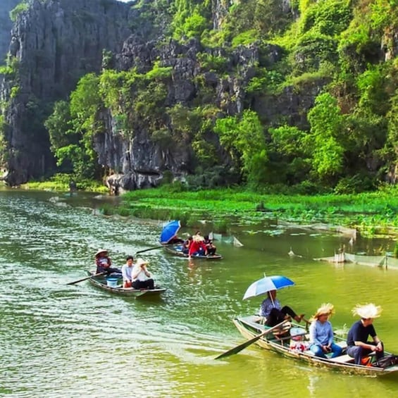 People paddling in boats on a river surrounded by lush greenery and rocky cliffs. 5