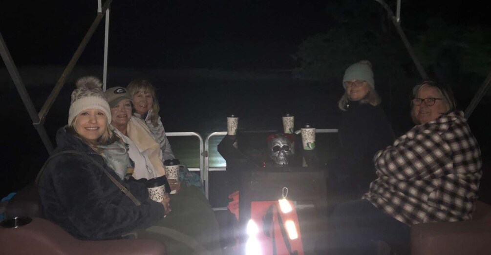 A group of people on a vehicle with a skull decoration. 3