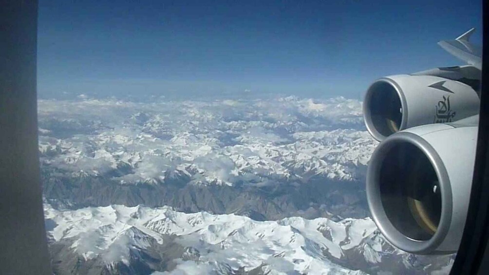 A view of snow-covered mountains from an airplane window. 5
