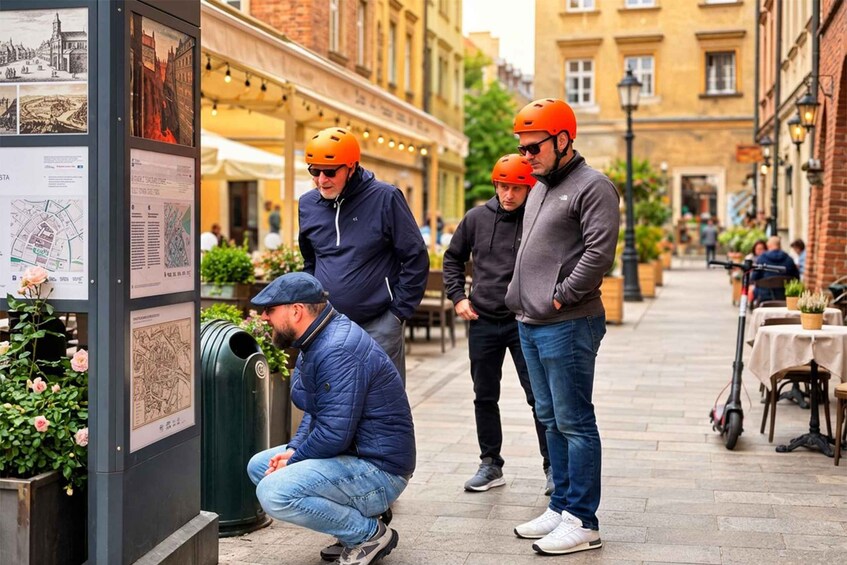 A group of people examining a map on a bulletin board in an urban street. 5