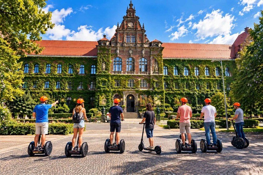 People on segways in front of a historic building with a red roof and green ivy. 3