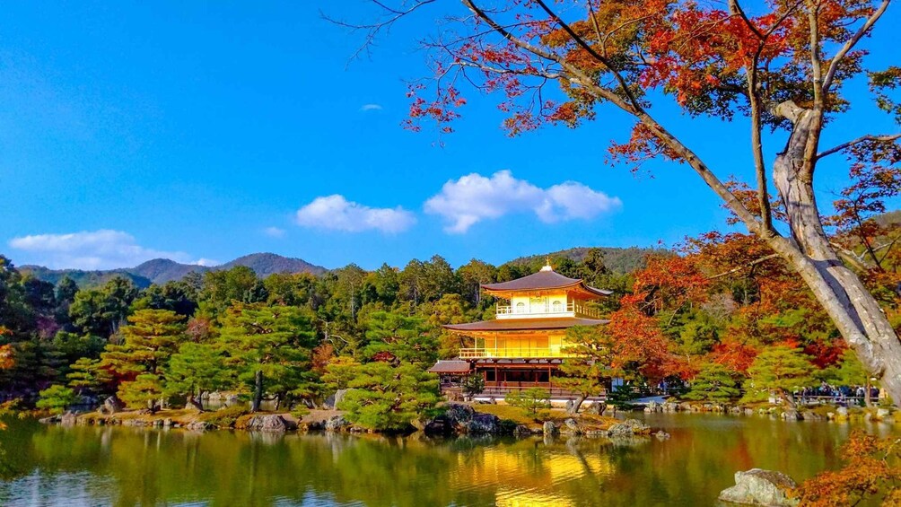 A traditional Japanese building by a lake with autumn foliage. 1