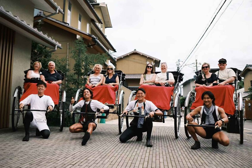 A group of people in wheelchairs and on bicycles, some with red blankets, in an outdoor setting with buildings in the background. 1