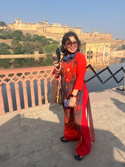 A person standing on a bridge with a historic fort in the background. 3
