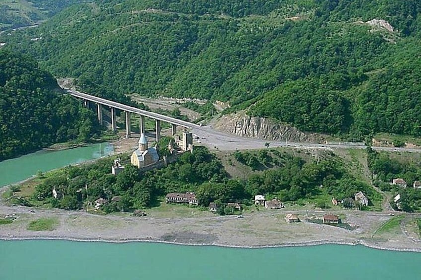 A bridge over a river, a hill with a building, and a small settlement. 3