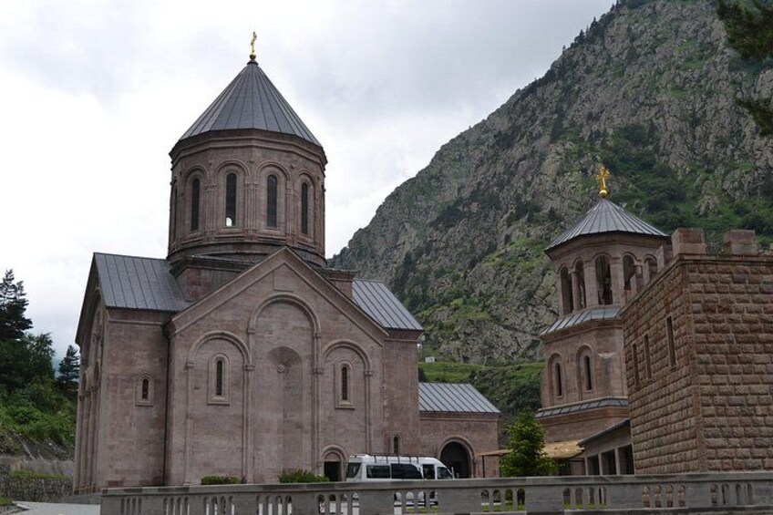 A church with a bell tower and a mountain backdrop. 5