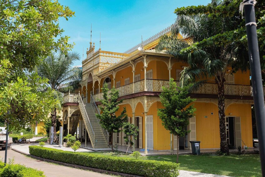 A yellow building with ornate balconies and a staircase. 5