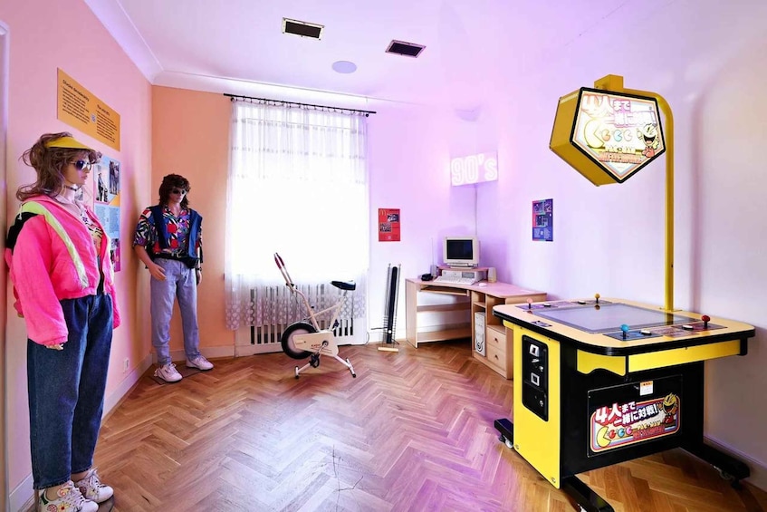 A room with a foosball table, exercise bike, and posters on the wall. 3