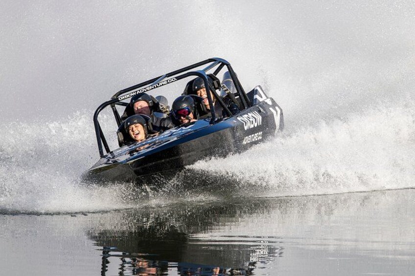 A speedboat with passengers, creating a large splash as it moves through water. 2