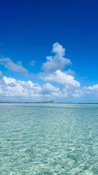 A clear blue sea with a distant island and a ship. 5