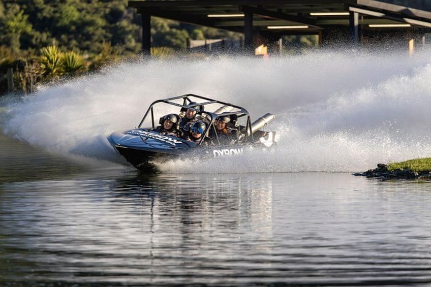 A speedboat with 'DYNOW' written on it, creating a large splash as it moves through the water. 5