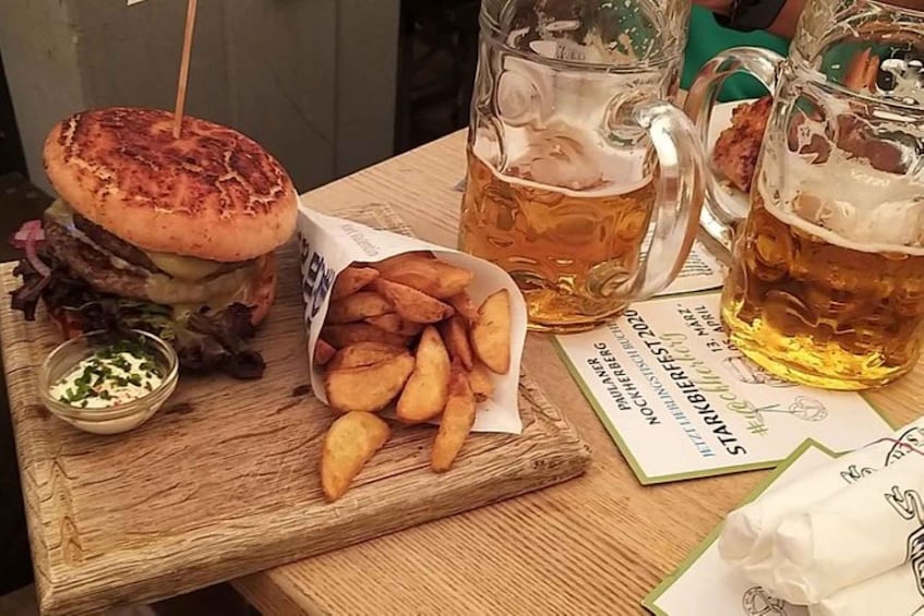 Hampurilainen, ranskalaiset ja olut puisella pöydällä. 5