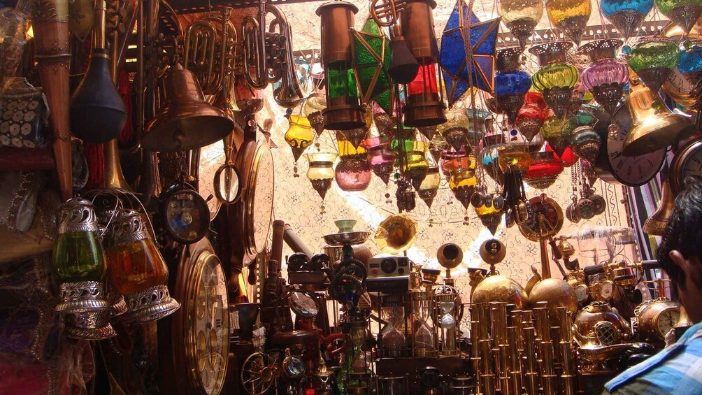 A variety of brass and glass items, including clocks, lamps, and decorative objects, displayed in a shop. 5