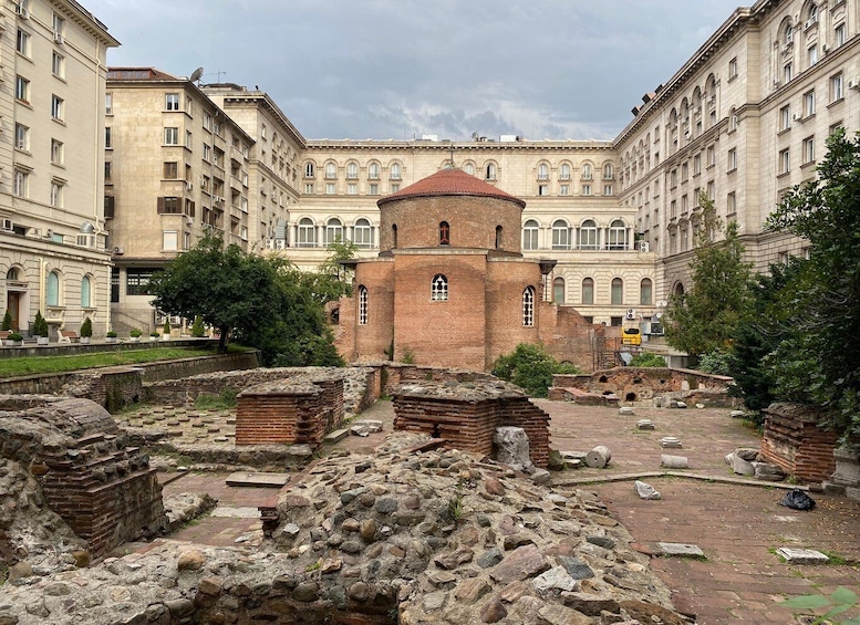 Ancient ruins with a central brick structure and surrounding stone walls. 2