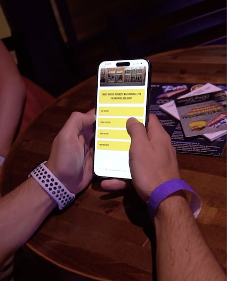 A person holding a smartphone with a quiz interface on a wooden table. 2