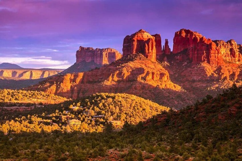 A desert landscape with prominent red rock formations and a small settlement in the foreground. 3