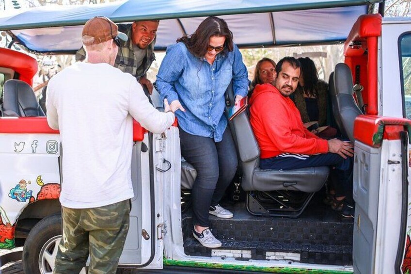 People boarding a vehicle with a colorful exterior and cartoon characters. 2