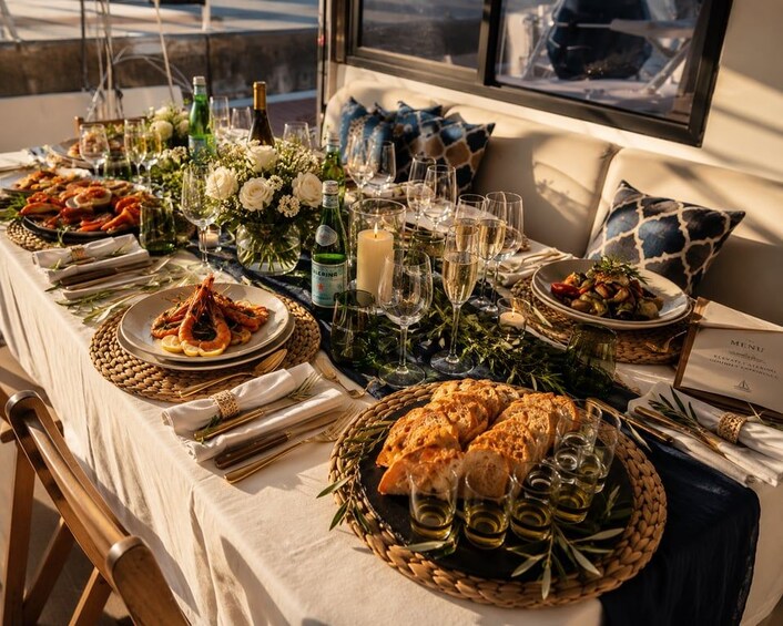Una mesa lista para comer, con platos de comida, vasos y un menú. 2