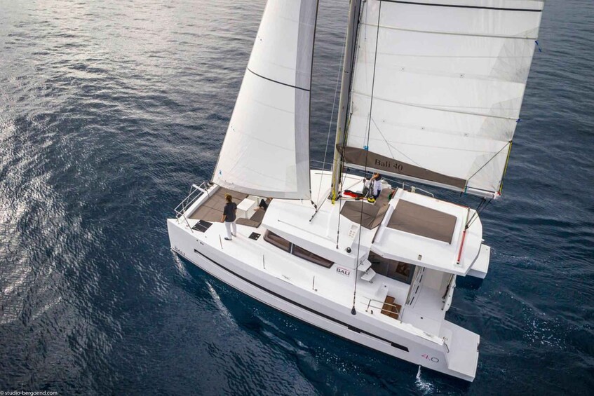 Un yate blanco con el nombre 'BALI' en su lateral, navegando sobre el agua. 3