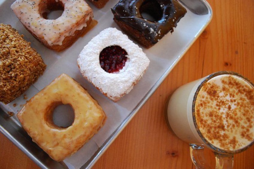 En bakke med forskellige donuts og et glas mælk med skum 1