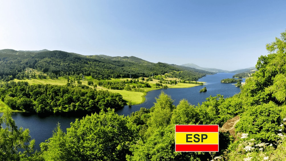 A river winding through a forested valley with hills in the background. 1