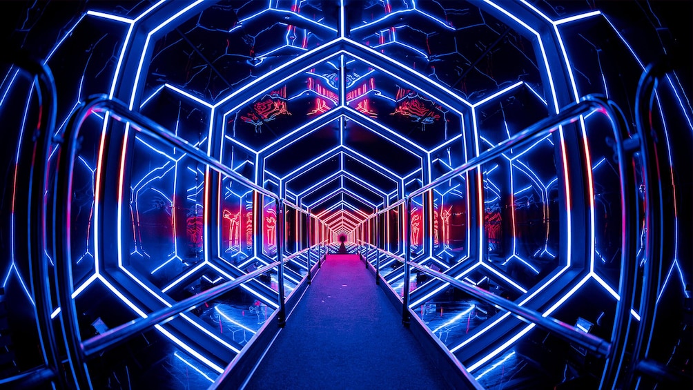 A neon-lit tunnel with geometric patterns and a central pathway. 4