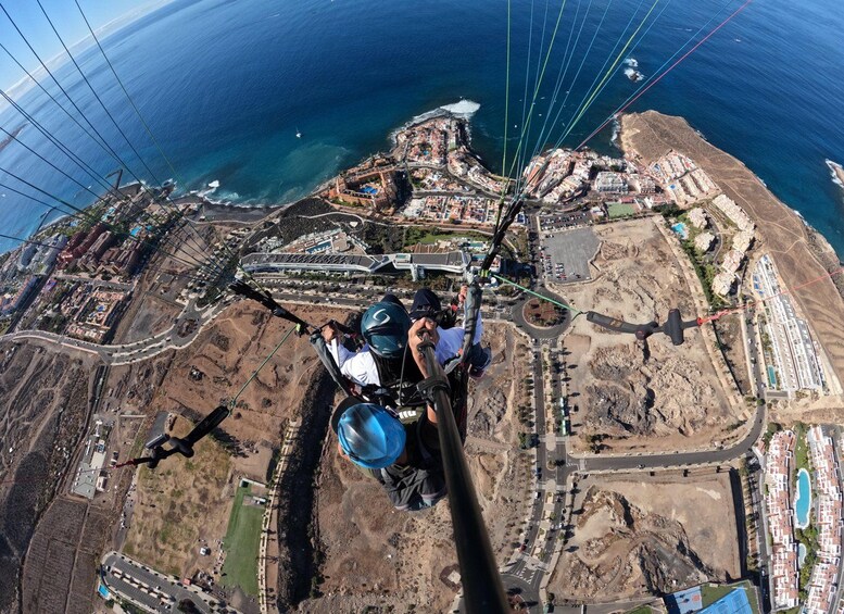 A group of people skydiving over a coastal area with buildings and a marina. 2