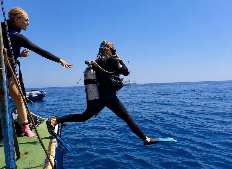 Two people in scuba diving gear preparing to enter the water. 5