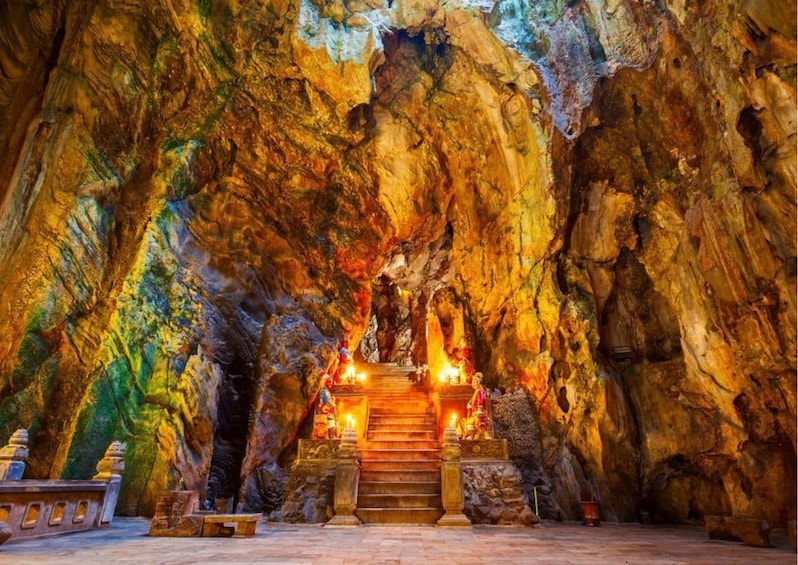A cave temple with a central staircase leading to a statue. 3