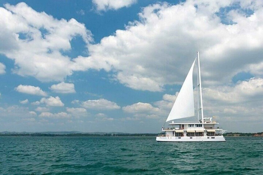 Un velero blanco en un mar tranquilo con cielo parcialmente nublado. 5