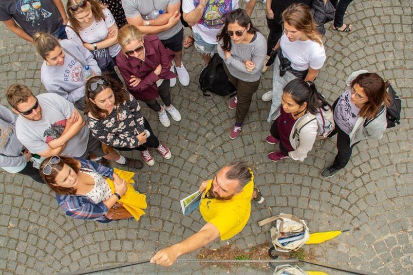 Eine Gruppe von Personen steht auf einer Kopfsteinpflasterstraße. 3