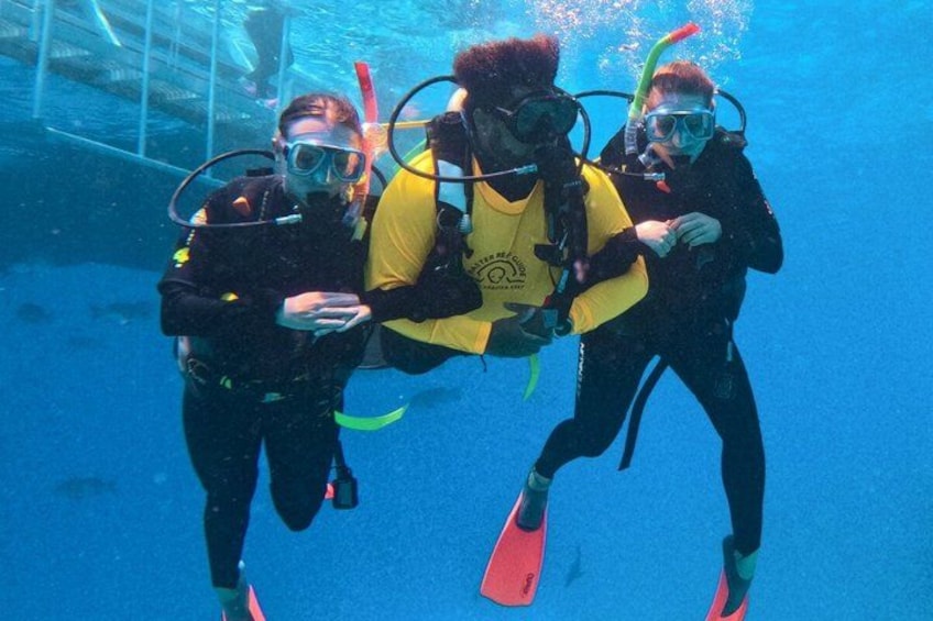 Three scuba divers underwater with fins and scuba gear. 2