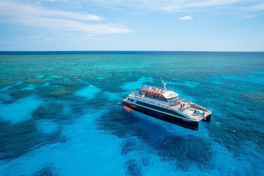 A large cruise ship on turquoise waters with clear skies. 1