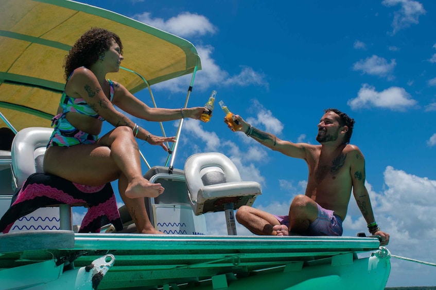 Two people toasting on a boat with a clear blue sky. 5