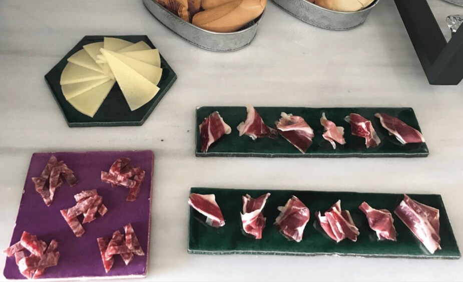 Una mesa con queso, jamón serrano y pan. 5