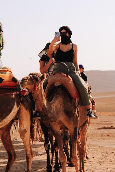 A person riding a camel in a desert landscape. 3