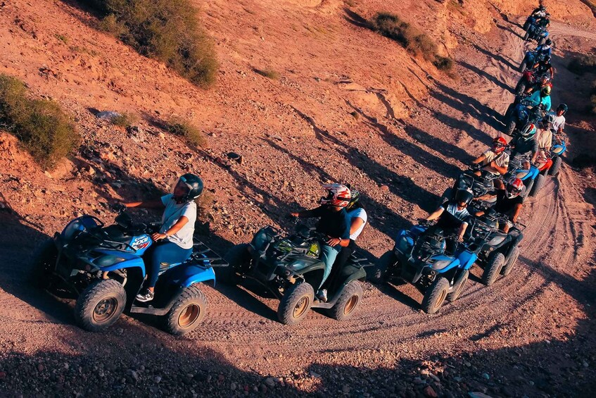 A group of people riding ATVs on a dirt trail. 1