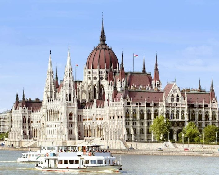 Un edificio storico con architettura elaborata e un fiume sullo sfondo. 1