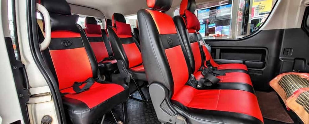 A vehicle interior with red and black seats, a steering wheel, and a dashboard. 4