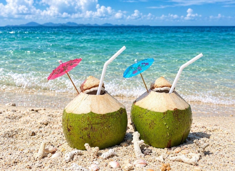 Twee kokosdranken op het strand, met parasols. 4