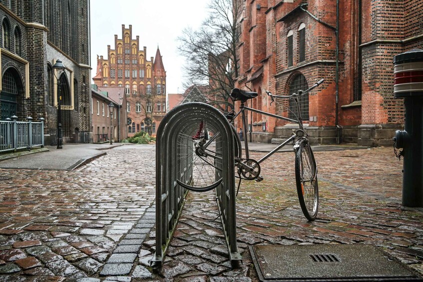 A bicycle parked on a cobblestone street with historic buildings in the background. 4