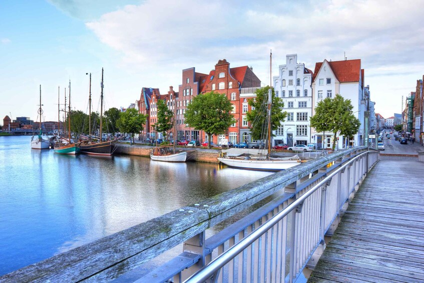 A canal with boats, a wooden walkway, and historic buildings along the water. 3